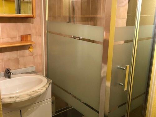 La salle de bains est pourvue d'un lavabo et d'une porte de douche en verre. dans l'établissement Villa T2 Mezzanine Climatisée, 6 Pers, Terrasse, à 350m de la Plage - Port Leucate - FR-1-81-445, à Port-Leucate