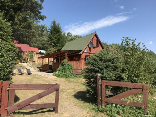 a wooden barn with a fence in front of it at Domek letniskowy nad jeziorem mazury Wilimy 127 in Wilimy