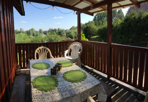 a wooden deck with a table and chairs on it at Domek letniskowy nad jeziorem mazury Wilimy 127 in Wilimy