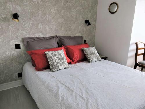 - une chambre avec un lit doté d'oreillers rouges et gris dans l'établissement Appartement avec loggia et balcon à Perros-Guirec - FR-1-368-295, à Perros-Guirec