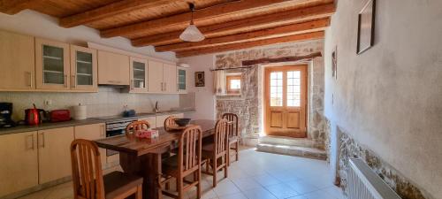 a kitchen with a wooden table and chairs in it at Ioanna 's Place in Sívas