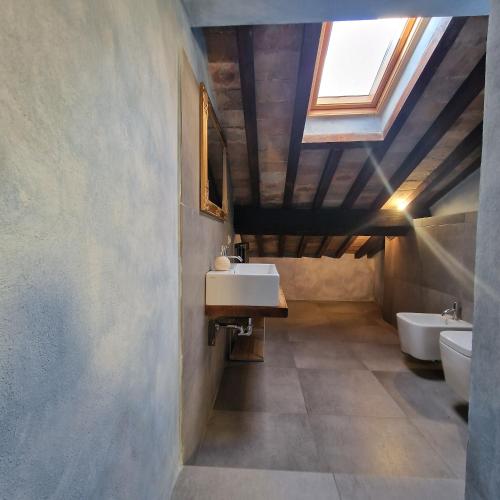 a bathroom with two sinks and a skylight at Borgo Il Cantuccio - Casa Grande con piscina condivisa in Molino di Renzetti