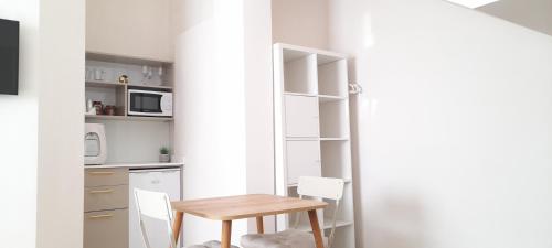 a small kitchen with a wooden table and chairs at Regina's place in Or ‘Aqīvāh