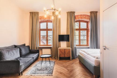 a living room with a couch and a bed at TILTŲ NAMAI Self Check-in Apartments in Klaipėda