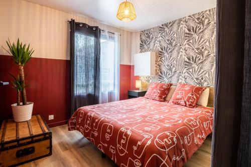 um quarto com uma cama com uma colcha vermelha e branca em Jolie Maison de ville proche centre-ville em Avignon