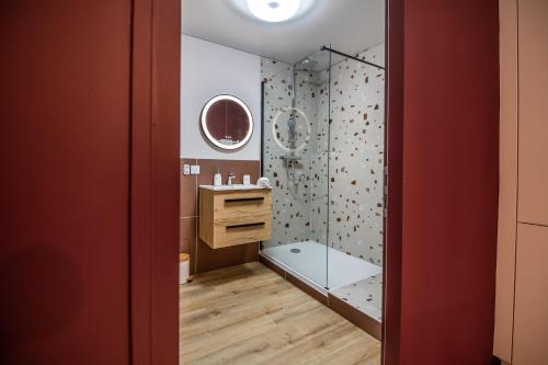 a bathroom with a glass shower with a sink at Jolie Maison de ville proche centre-ville in Avignon