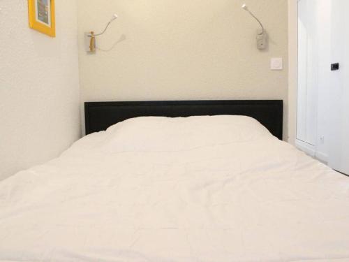 ein weißes Bett mit einem schwarzen Kopfteil in einem Schlafzimmer in der Unterkunft Appartement La Rochelle, 2 pièces, 4 personnes - FR-1-246-310 in La Rochelle
