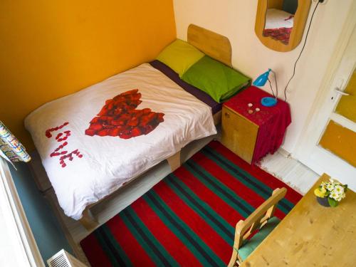 a small bed in a room with a table at Shantihome in Izmir