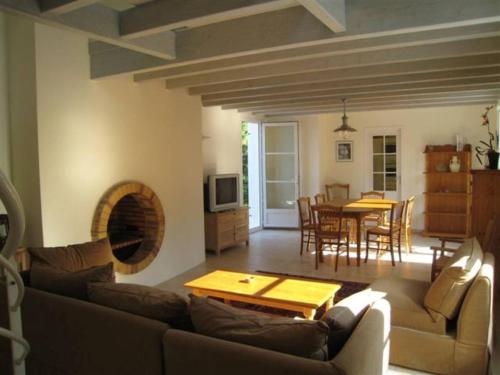 un salon avec un canapé et une table dans l'établissement Villa moderne à Saint Georges d'Oléron, 8 couchages, proche mer et commerces, parking et jardin - FR-1-246A-7, à Chaucre