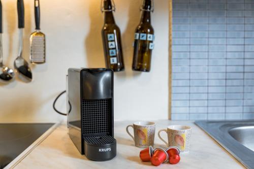 a microwave sitting on top of a kitchen counter with cups at Sant'Agata in Lixouri