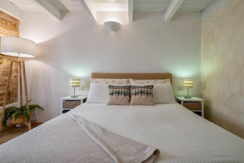 1 dormitorio con 1 cama blanca grande y 2 mesitas de noche en Little Flower, en Alghero