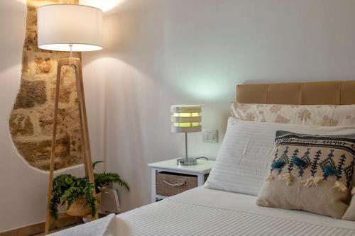 a bedroom with a bed and a lamp on a table at Little Flower in Alghero