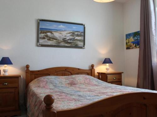 een slaapkamer met een bed en twee lampen en een foto aan de muur bij Maison Le Grand-Village-Plage, 3 pièces, 4 personnes - FR-1-246A-314 in Grand-Village-Plage
