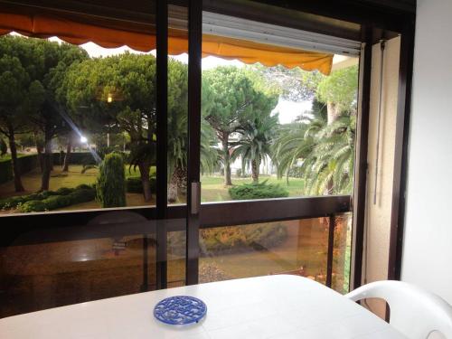 a room with a window looking out at a garden at Studio Le Grau-du-Roi, 1 pièce, 4 personnes - FR-1-307-114 in Le Grau-du-Roi