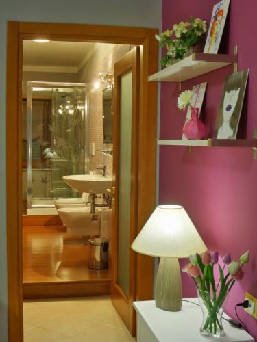 フォンディにあるIl Giardino delle Zagareの紫の壁のバスルーム(ランプ、シンク付)