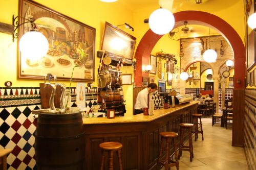 a man standing at a bar in a restaurant at Hotel Hermanos Macias in Ronda