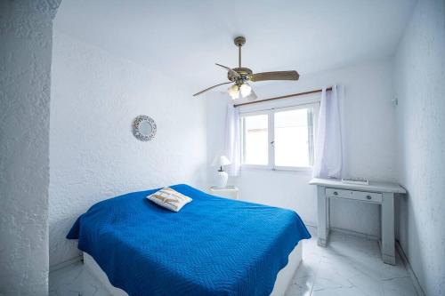 Un dormitorio blanco con una cama azul y una ventana en Casa duplex 2 dormitorios by depptö, en Punta del Este