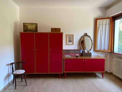 a room with a red cabinet and a mirror at Via Verdi 14 in Mondolfo