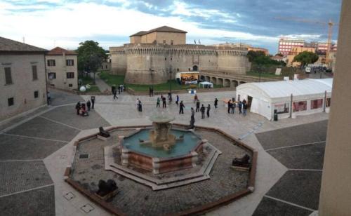 a group of people standing around a fountain in a courtyard at Via Verdi 14 in Mondolfo