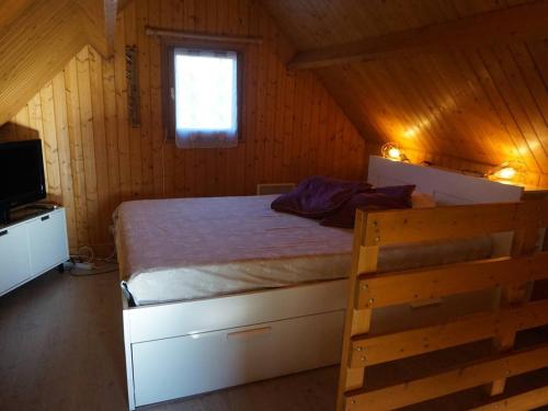 une chambre avec un lit dans une cabane en bois dans l'établissement Chalet avec piscine chauffée, tennis et jardin clos, à 1700m de la plage de Cabourg - FR-1-465-22, à Cabourg