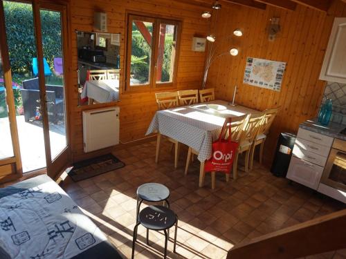une cuisine et une salle à manger avec une table et des chaises dans l'établissement Chalet avec piscine chauffée, tennis et jardin clos, à 1700m de la plage de Cabourg - FR-1-465-22, à Cabourg