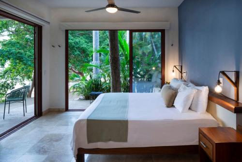 a bedroom with a large bed and a large window at Punta Monterrey in Lo de Marcos