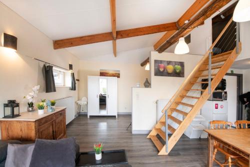 a living room with a spiral staircase in a loft at DE SMISHOEVE met kinderpret, dieren en wellness in Heers