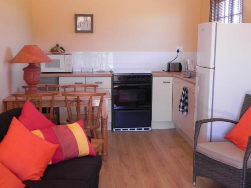 a kitchen with a refrigerator and a table with chairs at J&B Lodge in Underberg