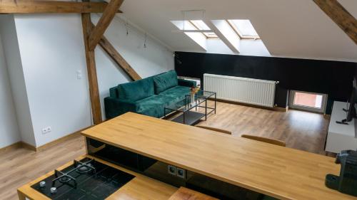 sala de estar con sofá verde y mesa en Loft w centrum Gliwic en Gliwice