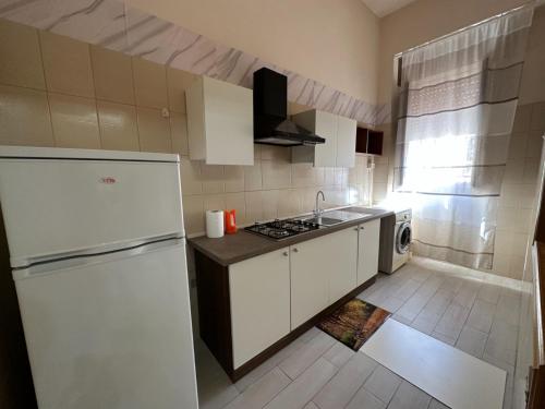 uma pequena cozinha com um frigorífico e um lavatório em Casa Mia Russotto 3 Sicilia em Niscemi