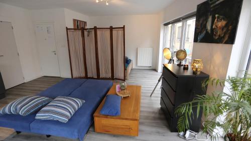 a living room with a blue bed and a table at Studio 200 meters from Central station in Antwerp