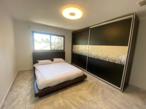 um quarto com uma cama branca e uma janela em Vila kasa vali em Zekharya