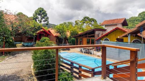 uma casa com uma piscina e uma cerca em Pousada Chalana em Monte Verde