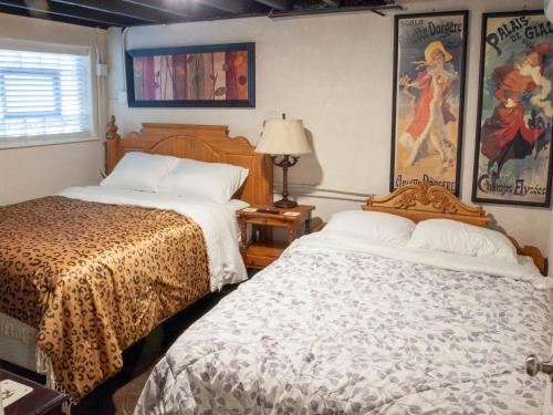 een slaapkamer met 2 bedden, een lamp en een raam bij Bootlegger House Sleeps 10-20 Free TV & Parking in Chicago