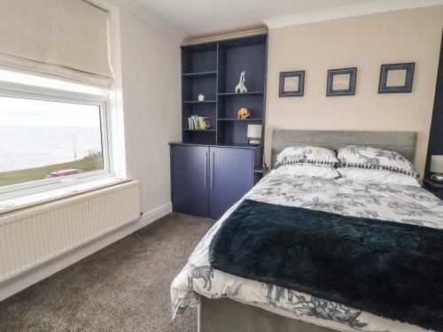 a bedroom with a large bed and a window at Ty Canol in Rhyl