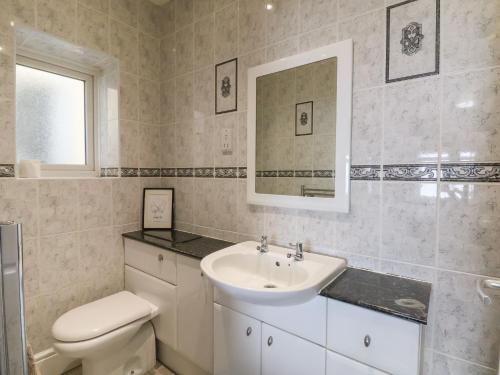 a bathroom with a sink and a toilet and a mirror at Ty Canol in Rhyl