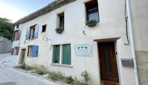 - un bâtiment blanc avec des fenêtres et une porte dans l'établissement Maria Magdalena Apartments, à Rennes-le-Château