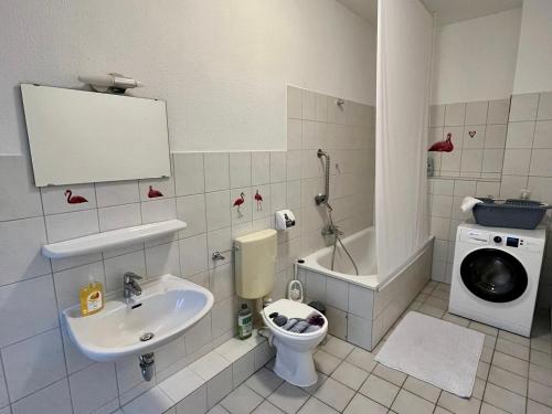 y baño con lavabo, aseo y lavadora. en Central Apartments - Work&Stay, en Neumünster