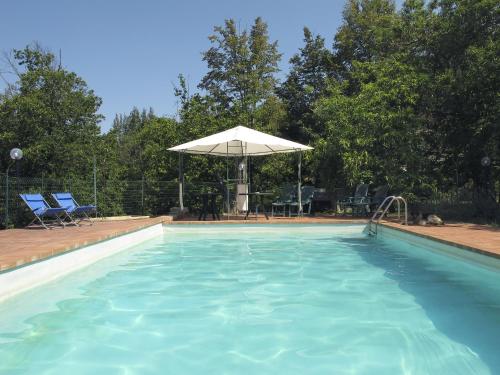 - une grande piscine avec un parasol blanc dans l'établissement Agriturismo La Leggenda, à Santa Fiora