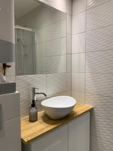 ein Badezimmer mit einem weißen Waschbecken auf der Theke in der Unterkunft W Muzycznej Dzielnicy in Bydgoszcz