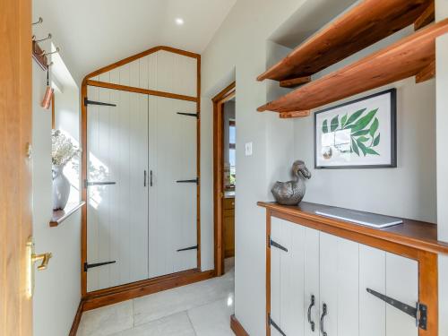 a bathroom with white cabinets and a mirror at The Farm House in Shipton under Wychwood