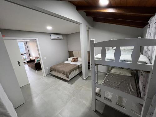ein Schlafzimmer mit einem Etagenbett und ein Zimmer mit einem Etagenbett in der Unterkunft Apartamento Frente Mar Vista Lateral in Bombinhas