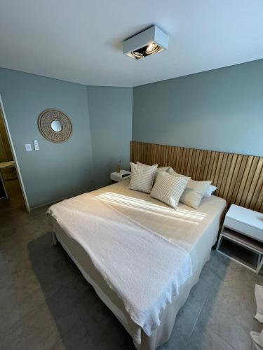 1 dormitorio con 1 cama grande con sábanas blancas en Velez Sarsfield Village con Pileta en Córdoba