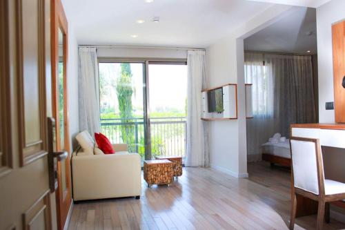 a living room with a couch and a large window at Yarden Estate Hotel in Yesod Hamaala