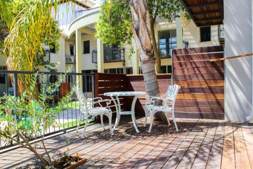 a patio with two chairs and a table and a tree at Yarden Estate Hotel in Yesod Hamaala