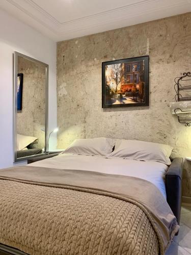 une chambre avec un grand lit avec un tableau au mur dans l'établissement Cannes studio cosy, à Cannes
