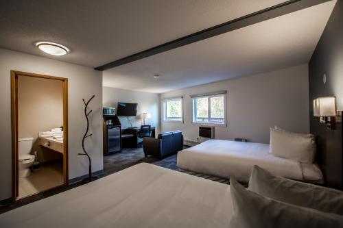 a hotel room with two beds and a desk at Bedrock Motel in Mayo Landing