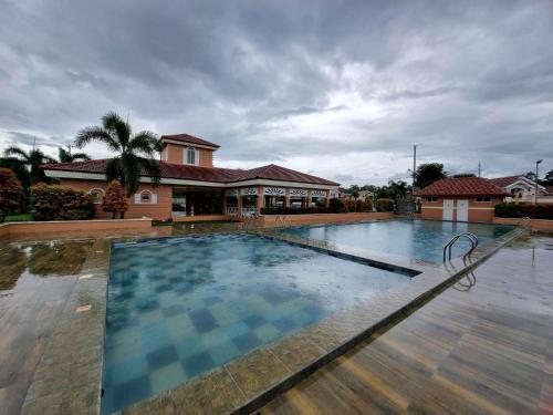 a large swimming pool in front of a house at Palawan two bedroom home in puerto princesa city in Puerto Princesa City