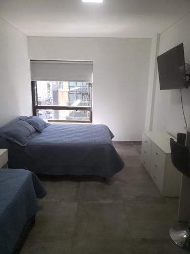 1 dormitorio con cama, ventana y TV en Av. Corrientes 818 - Ciudad de Buenos Aires - en Buenos Aires