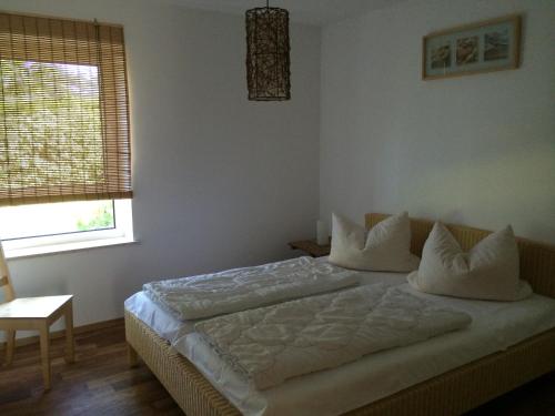 a bedroom with a bed with white sheets and pillows at Ferienresidenz Am weißen Regen in Bad Koetzting
